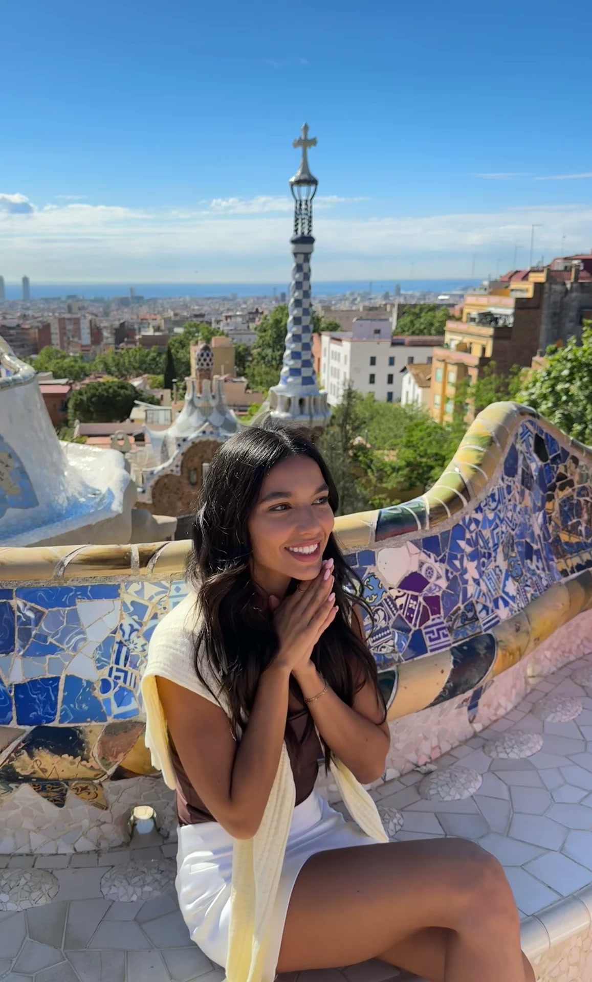 White mini skirt and knit shrug at Park Güell in Barcelona